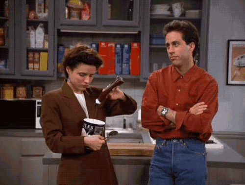 a man and a woman are standing in a kitchen and the woman is holding a bottle of milk