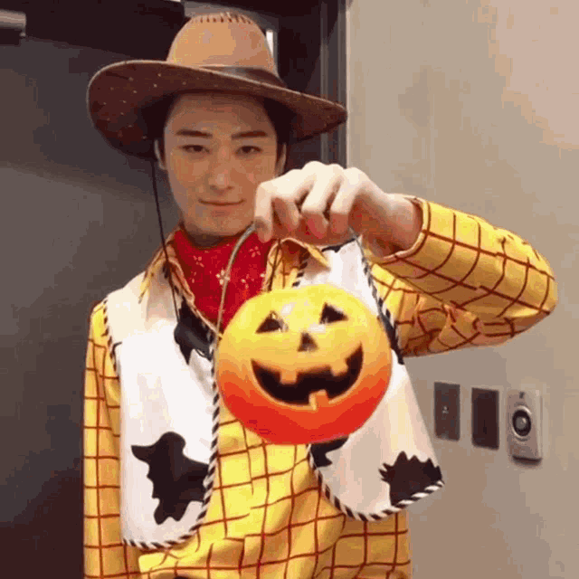 a man in a woody costume holds a pumpkin