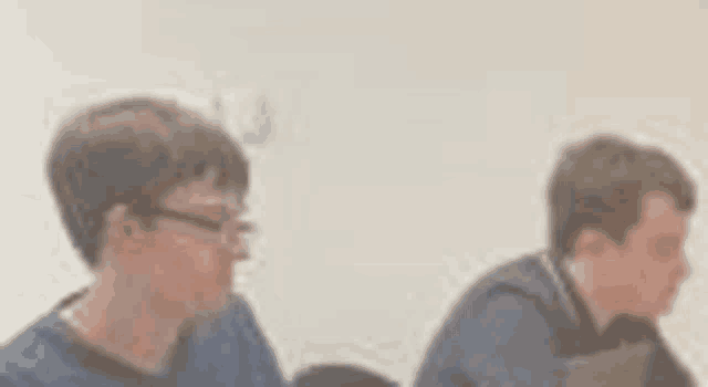 a blurry picture of two men sitting at a table .