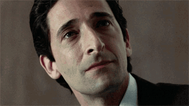 a close up of a man 's face with a slight smile on his face