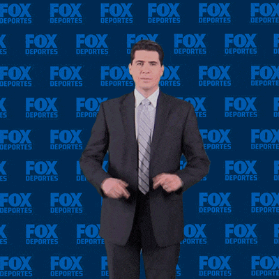 a man in a suit is standing in front of a fox deportes background