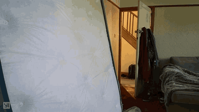 a mattress is sitting in a living room next to a door
