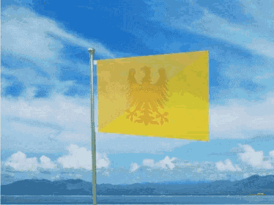 a yellow flag is flying in the wind in front of a body of water