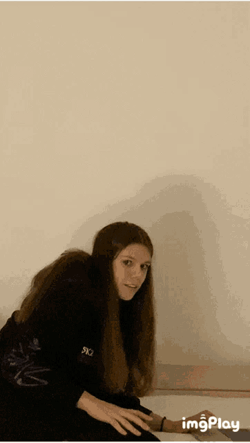 a girl with long hair wearing a black shirt that says ' sx3 ' on it
