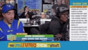 a man in a blue hat is sitting at a table in front of a sign that says the double eating show