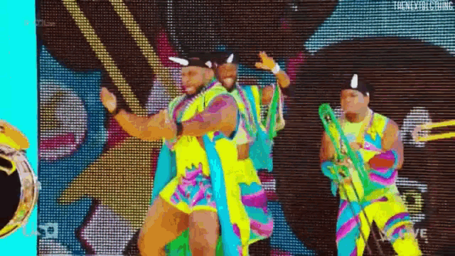 a couple of men are dancing in front of a large screen .