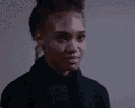 a close up of a woman 's face with a black shirt on .