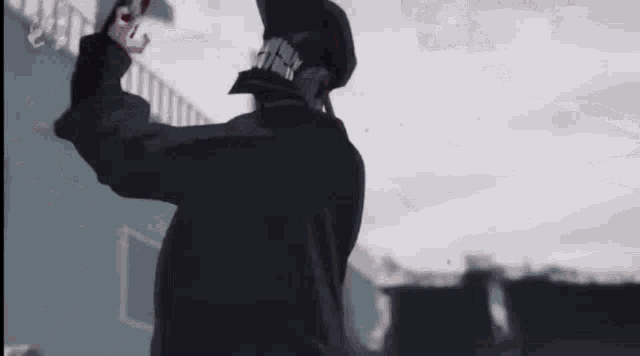 a man in a black coat is holding a gun in his hand in a video game .