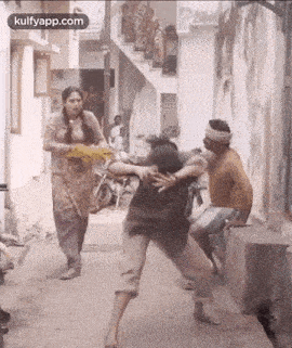 a man and a woman are fighting in a street .