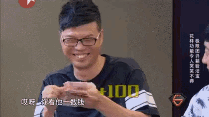 a man wearing glasses and a shirt that says 100 is holding a piece of paper