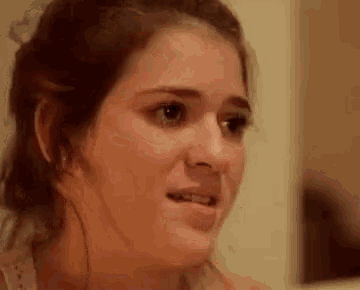 a close up of a woman 's face with a slight smile on it .