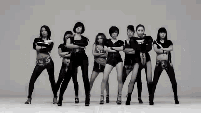 a group of women standing in a row with their arms crossed