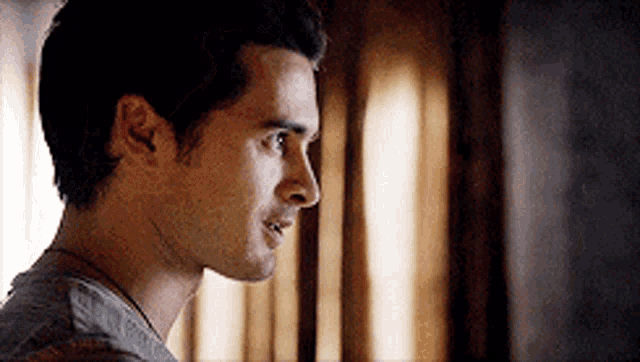 a close up of a man 's face in a room with a window in the background .
