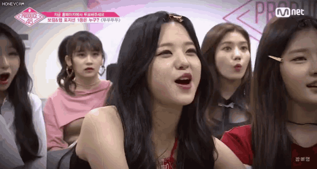 a group of girls are sitting in a room with their mouths open and one of them is laughing .