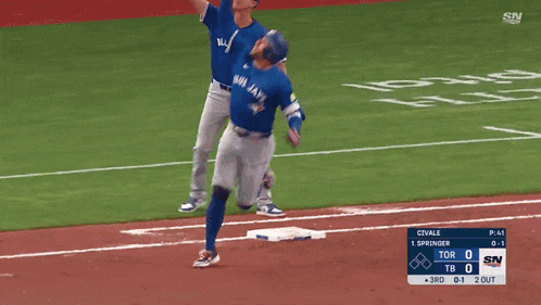 a blue jays player reaches for the ball during a baseball game