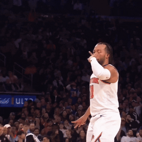 a basketball player giving a thumbs up in front of the crowd