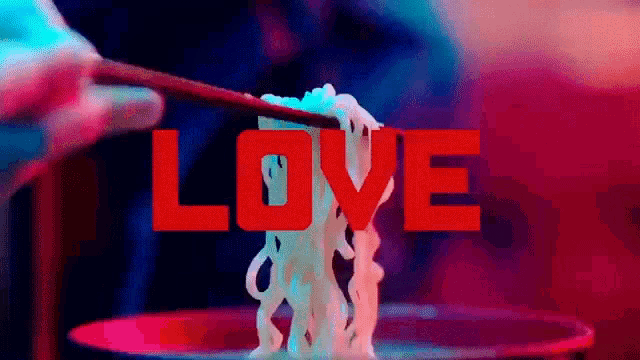 a person is holding chopsticks over a bowl of noodles with the word love in the background .