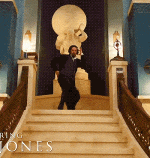 a man is standing on a set of stairs in front of a statue with the words ring jones on the bottom