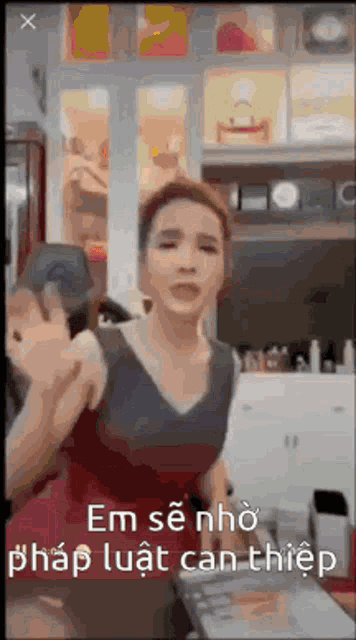 a woman in a red dress is giving a thumbs up sign in a room with a foreign language .