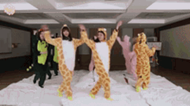 a group of people in giraffe costumes are dancing together in a room .