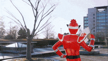 a red superhero is holding a fan in his hand