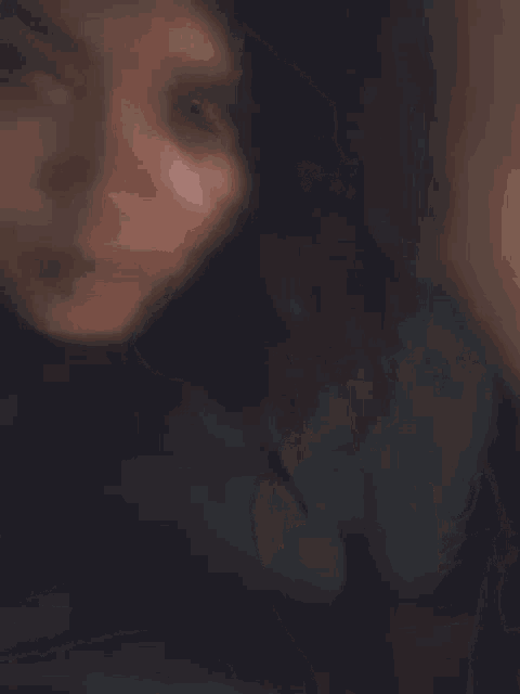 a close up of a woman 's face with a red spot on her face