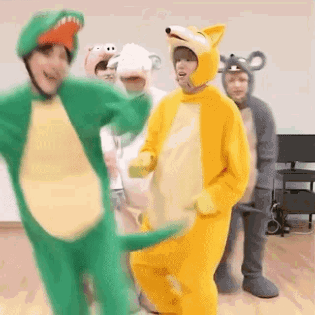 a group of people dressed in animal costumes are dancing together in a room .