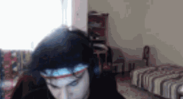 a man wearing headphones and glasses is sitting in a room .