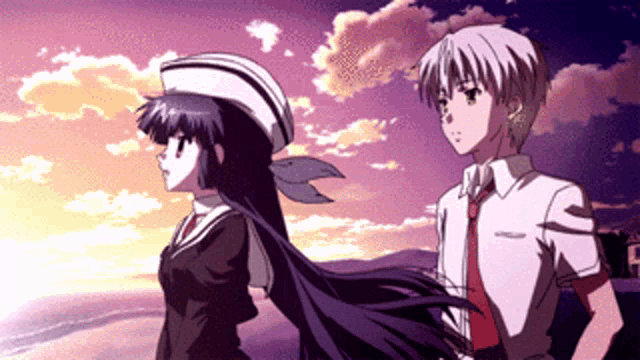 a boy and a girl standing next to each other in front of a sunset