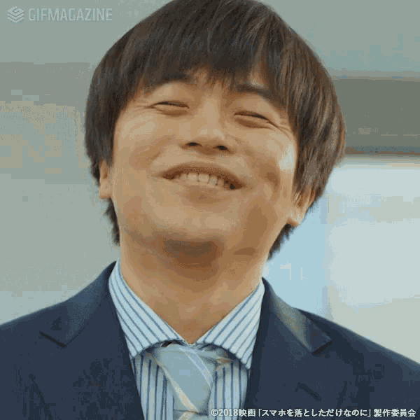 a man in a suit and tie is smiling with a gifmagazine watermark behind him