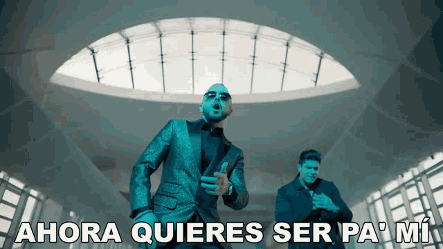 a man in a suit stands next to another man with the words " ahora quieres ser pa mi " on the bottom