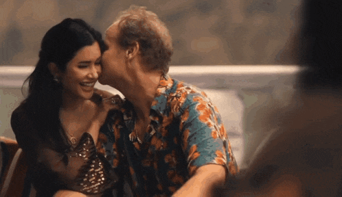 a man is kissing a woman on the cheek