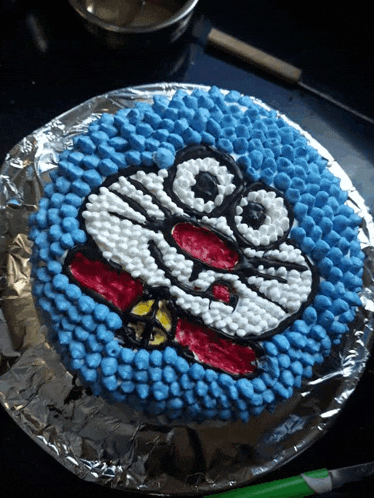 a blue and white cake with a doraemon face drawn on it