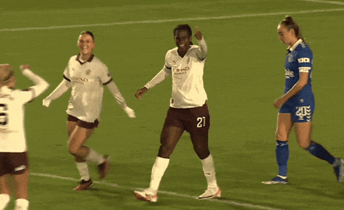 a soccer player wearing a number 6 jersey high fives her teammate