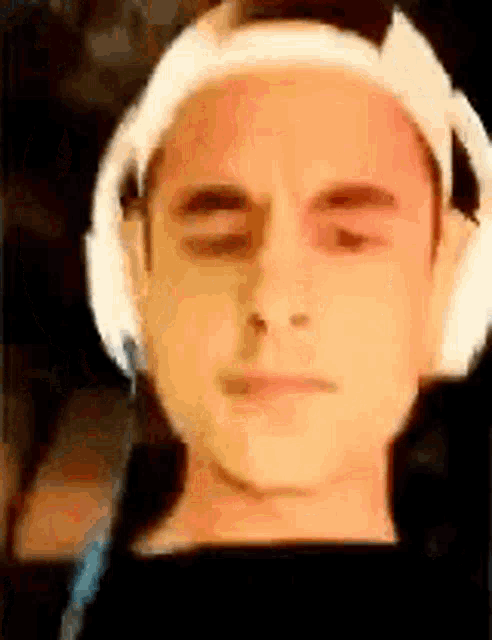 a close up of a man wearing headphones and looking at the camera .