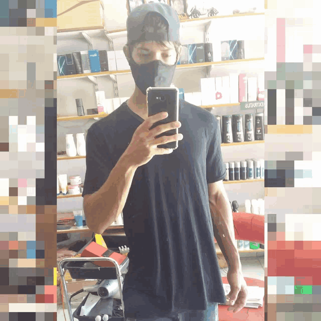 a man wearing a mask takes a selfie in front of a shelf that says guarantia