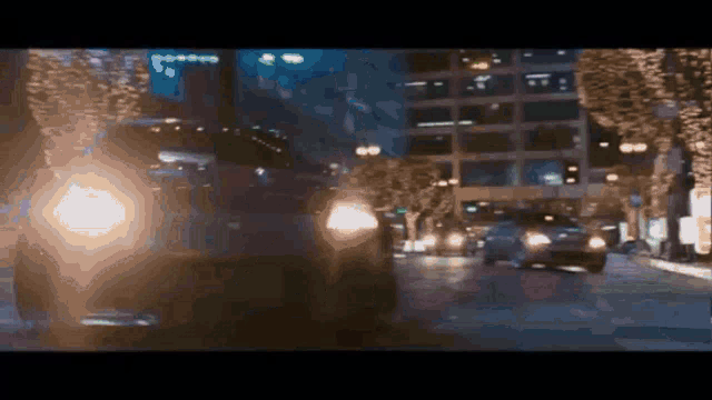 a blurry picture of a city street at night with cars driving down it