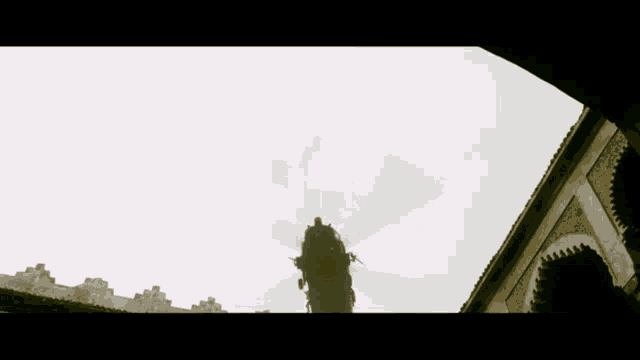 a silhouette of a building with a tree in the background