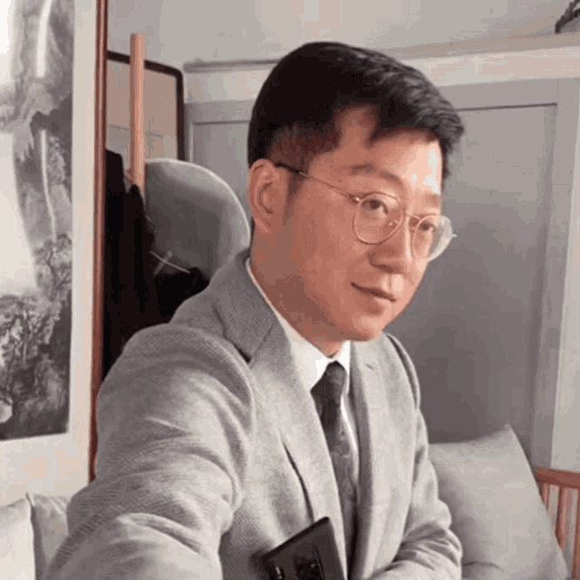 a man in a suit and tie holds a cell phone