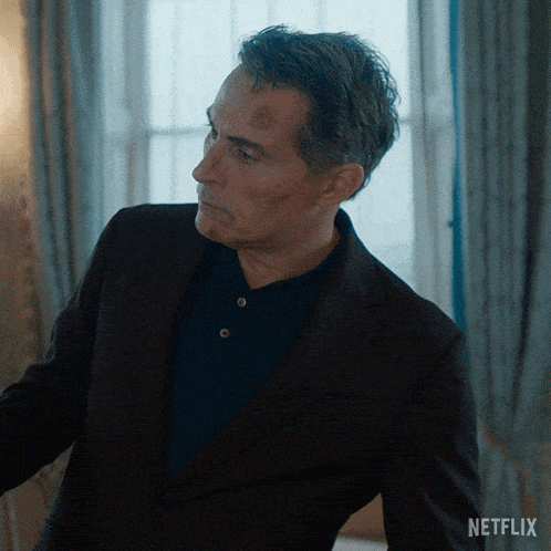 a man in a suit has a netflix logo on the bottom of his jacket
