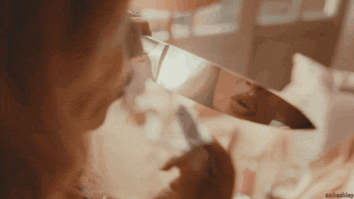 a woman looks at her reflection in a mirror with the name ashley visible