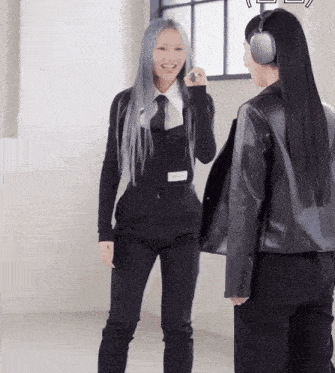 a woman wearing headphones talks to another woman in a room