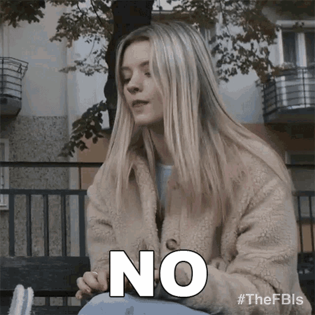 a woman in a fur coat is sitting on a bench and saying no .