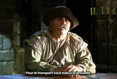 a man sitting at a table with the words pour le transport vaut mieux la brouette above him