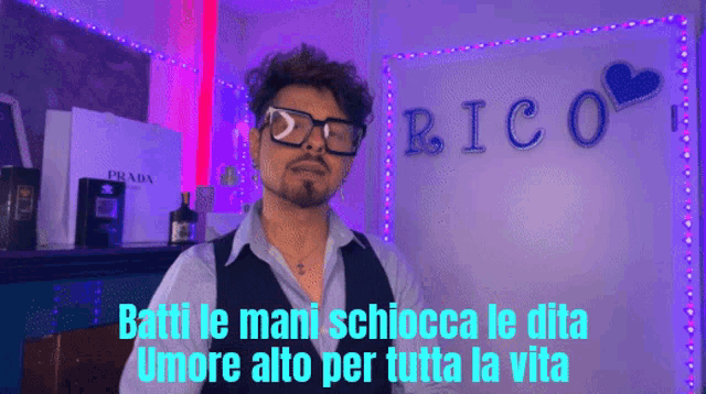 a man stands in front of a wall with the word rico on it