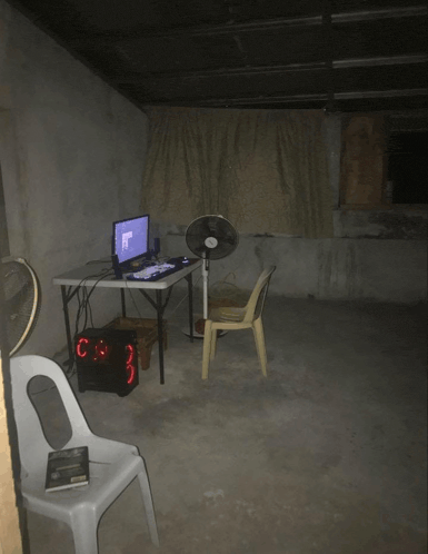 a chair sits in front of a table with a computer on it