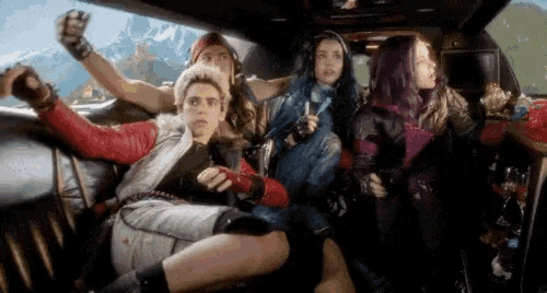 a group of young people are sitting in the back seat of a car .