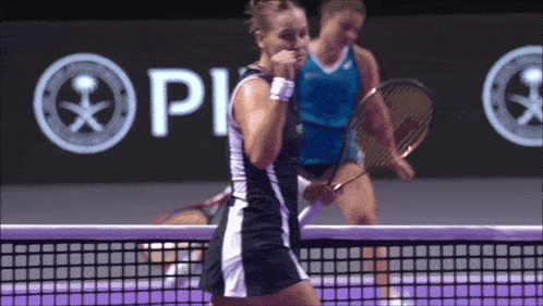 two female tennis players on a court with a sign that says pi in the background