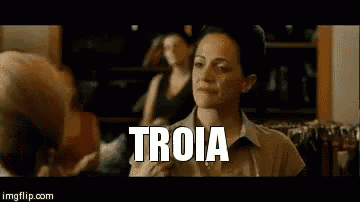 a woman is sitting in front of a group of people and the word troia is on the screen .