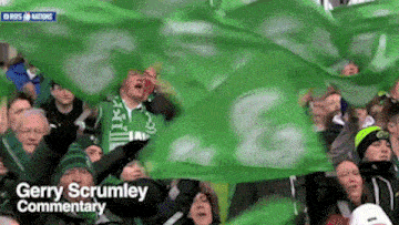 a crowd of people holding green flags with the words gerry scrumley commentary written on the bottom
